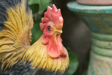 Close up shot of a rooster statue for decoration put isolated in the garden.