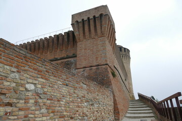 the fortress of Brisighella with mighty brick walls, two towers and the patrol walkway stands on a hill that dominates the village