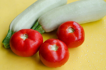 zucchini and tomatoes on a yellow background close-up