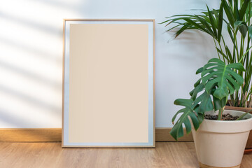 Boho wood frame vertical monograph mockup on clean white walls, plants and sun rays.