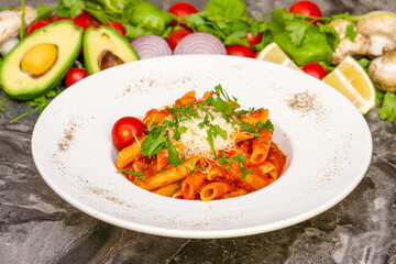 Penne pasta in tomato sauce, tomatoes decorated with parsley on a wooden background