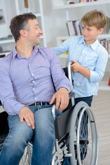 man on the wheelchair and a boy at his back