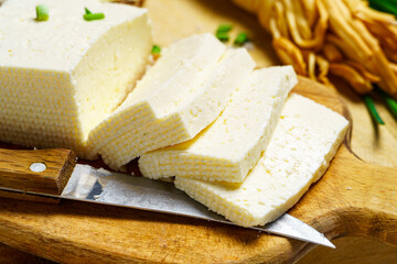 tasty lunch in rural style, healthy food - sliced feta cheese, eggs and green leek, cooked food on a white wooden boards