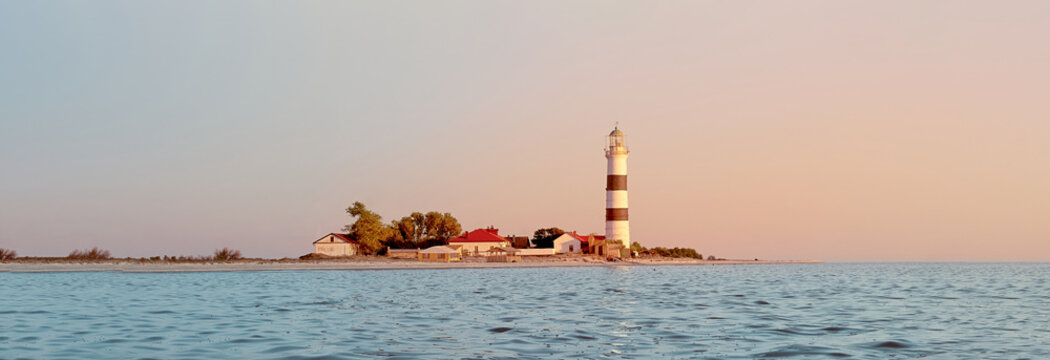 Panoramic view of a lighthouse. Lighthouse on Tendra Spit, Kherson Oblast, Ukraine. Banner. Copy space.