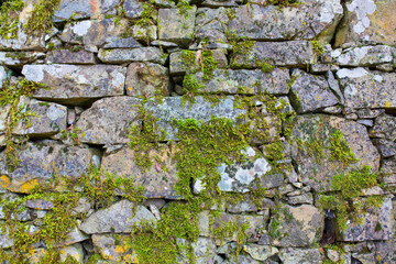 Stone antique old wall as a background or texture. Vintage background of a fortress wall in loft and grunge style with place for text and copy space.