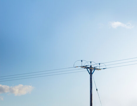 An overhead power line against the blue sky