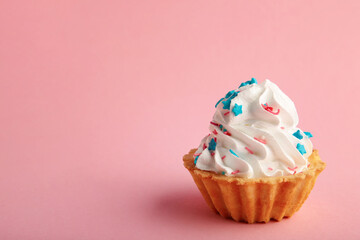 Vanilla cupcakes decorated with sprinkle on pink background with copy space.