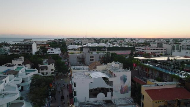 Playa Del Carmen neighborhood rooftops reveal busy street at night - aerial