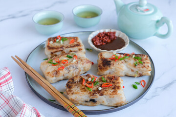 Popular Chinese New Year food. Turnip Cake aka Lo Bak Go. Actually made from radish and rice flour. For own consumption, you can add ground pork, diced Chinese sausage and mushroom and pan fried.