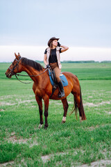 Vertical confident tone horse woman hat, holding hair, harness, looking distance ranch, dressage,...
