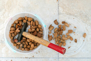 break dry shelled almonds with hammer. hammer and dry almonds, - obrazy, fototapety, plakaty