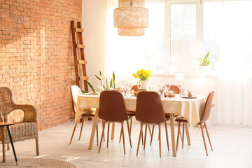 Interior of light room with table set for Easter celebration near window