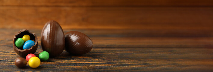 Chocolate Easter eggs on wooden background with space for text