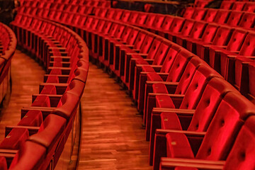 rows of red velour chairs in the auditorium of the opera house