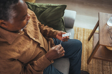 Old senior African American male hand nasal swab testing rapid tests by himself for detection of the SARS co-2 virus at home isolate quarantine concept