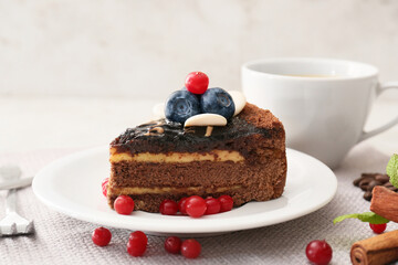 Plate with delicious piece of chocolate cake and berries on light table