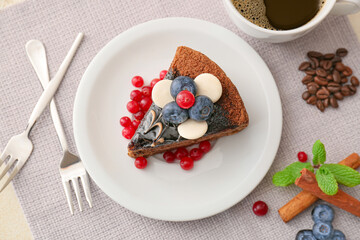 Plate with delicious piece of chocolate cake, berries and cup of coffee on light background