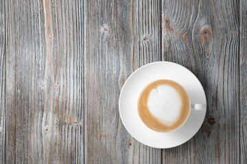 Fragrant cappuccino in white cup flat lay gray wood background. Cappuccino on wooden background flat lay.