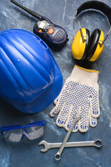 Safety equipment with builder's tools and radio transmitter on color background