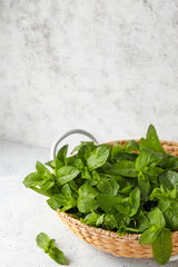 Wicker basket with mint on table