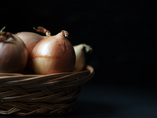 Onion in a basket, low key photography, black background