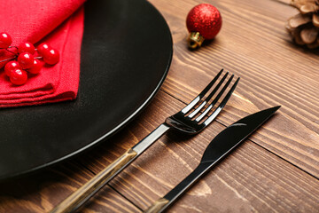 Plate and set of cutlery for Christmas celebration on wooden background