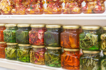 Fototapeta na wymiar Exotic jam from spruce branches, mountain herbs and berries in glass jars. Selective focus