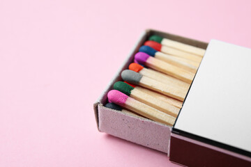 Box with new matchsticks on pink background, closeup