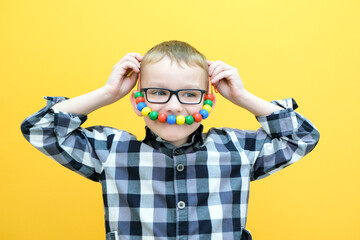 development of fine motor skills. Toddler boy is stringing beads on a string. happy child. smile beads