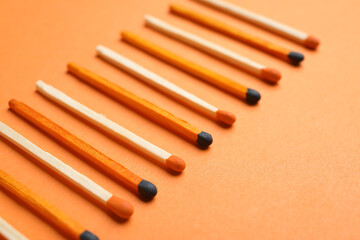 Different new matchsticks on orange background