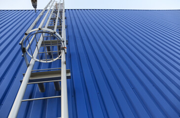 Fire escape metal ladder of blue building outdoors