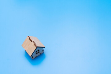 Fototapeta premium small toy wooden house on a blue background