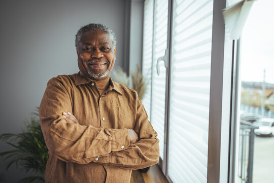 African American Senior Man at home Portrait. Smiling senior man looking at camera. Portrait of black confident man at home. Portrait of a senior man standing against a grey background