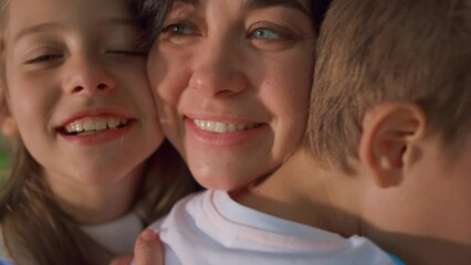Smiling mother enjoy cuddling with children close up. Happy family moments.
