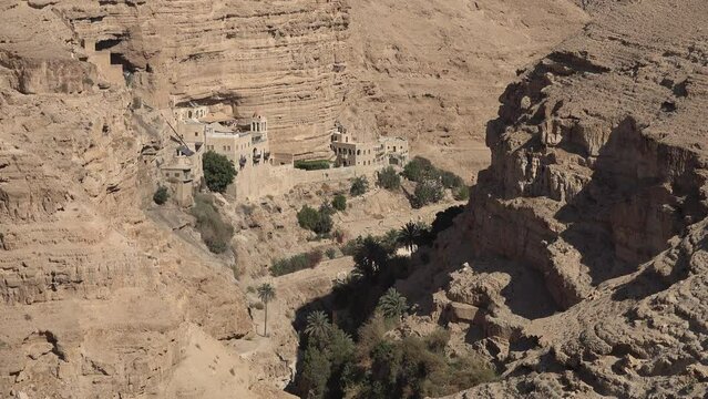 Panoramic view of St. George Greek Orthodox monastery, built in narrow gorge among spectacular mountain landscape in the Palestinian Territories
