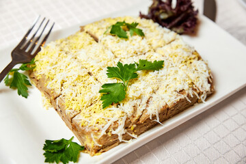 Liver cake with cheese on a white plate