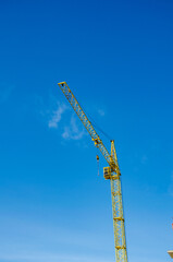 crane Infrastructure and Construction. yellow crane on a blue sky background.