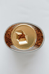 Top view of a glass jar of coffee without a lid, the gold-colored label is torn, the integrity of the packaging is broken, the background. Close-up.