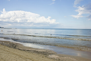 seascape. sandy seashore, sea and cloudy sky