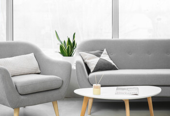Table with reed diffuser and magazine in light living room