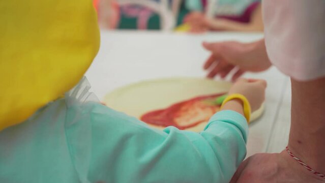 Workshop for little children how yo make pizza. Kids learning making pizza with chef teachers