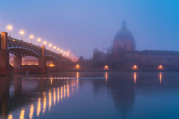 Garonne river and Dome of the 'Hopital de la Grave' at sunrise in fog in Toulouse, France