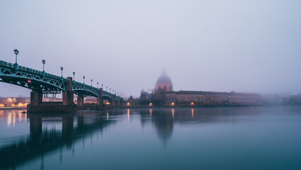 Garonne river and Dome of the 'Hopital de la Grave' at sunrise in fog in Toulouse, France
