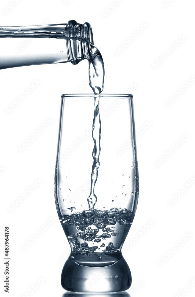 Wall mural Pouring of clear water in glass isolated on white