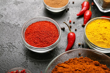 Bowls with aromatic spices on dark background, closeup