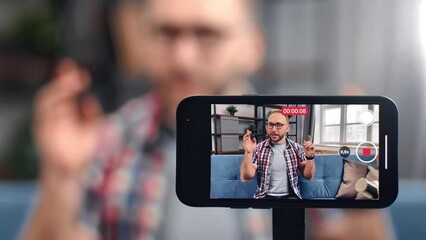 Friendly male blogger recording video use smartphone screen communicating to audience gesticulating - Powered by Adobe