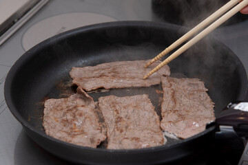 IHのフライパンで肉を焼く