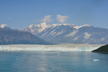 Alaska ice Floe  into ocean with snow covered mountains as a backdrop , a sight that may well disappear due to Global warming and climate change.