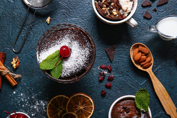 Glass bowl and cups with tasty chocolate brownie on black background