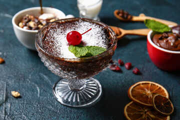 Glass bowl with tasty chocolate brownie on black background